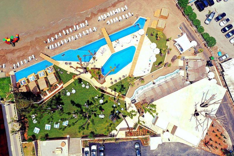 Aerial view of a beach club with pools, lawns and mature trees