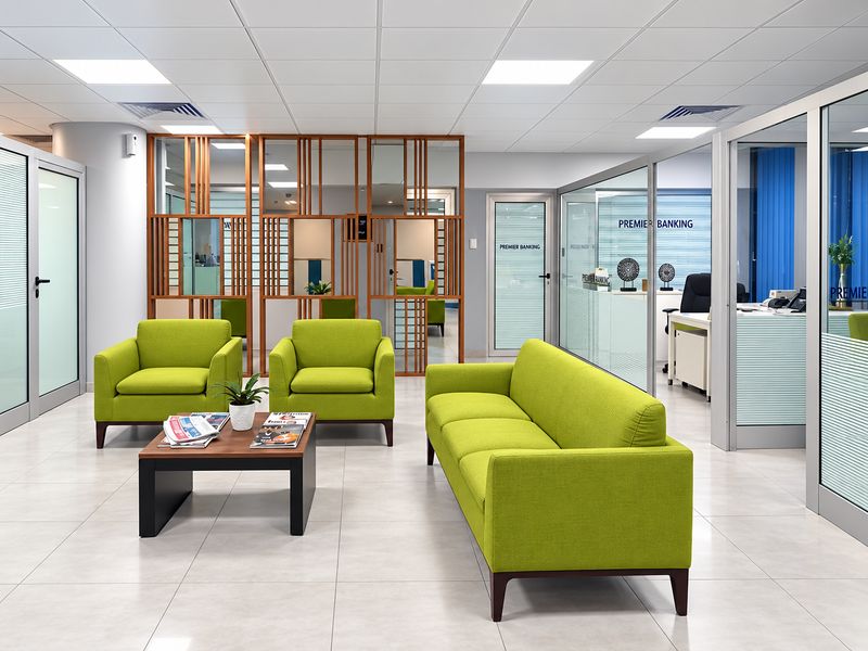 Office reception with lounge seating and glass-partitioned offices