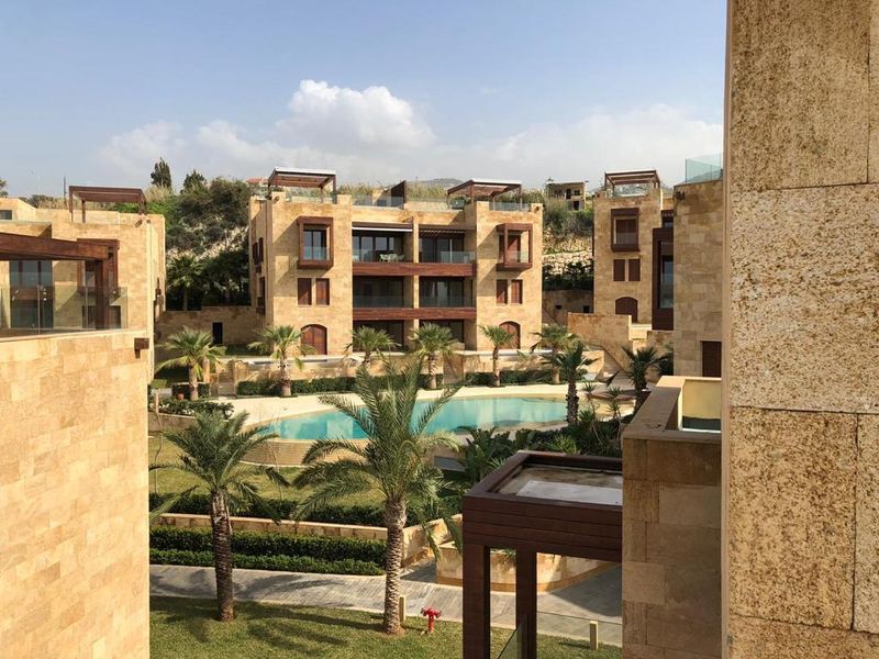 Stone-clad residential buildings around a landscaped pool courtyard